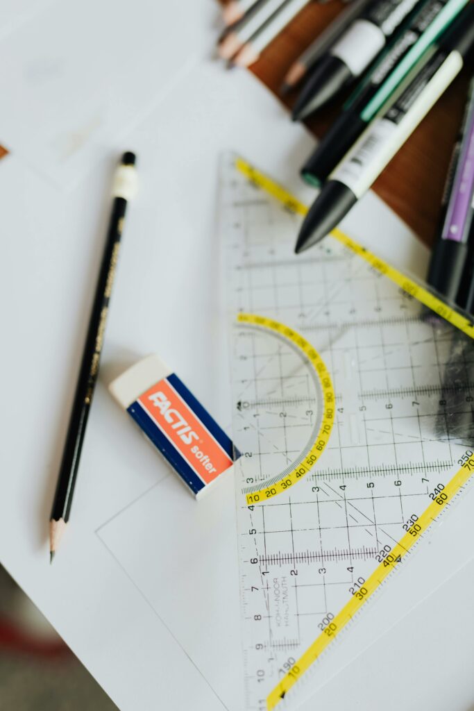 Pencils, markers, and triangle ruler on a desk, ideal for educational themes.