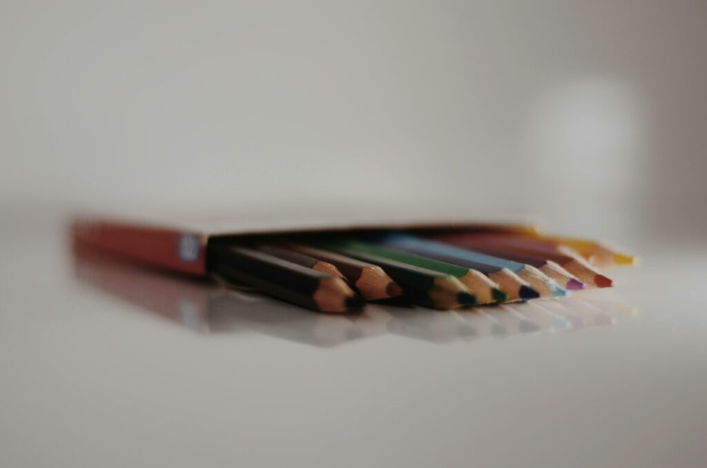 Vibrant colored pencils in a box, showcasing depth of field with a minimalist background.