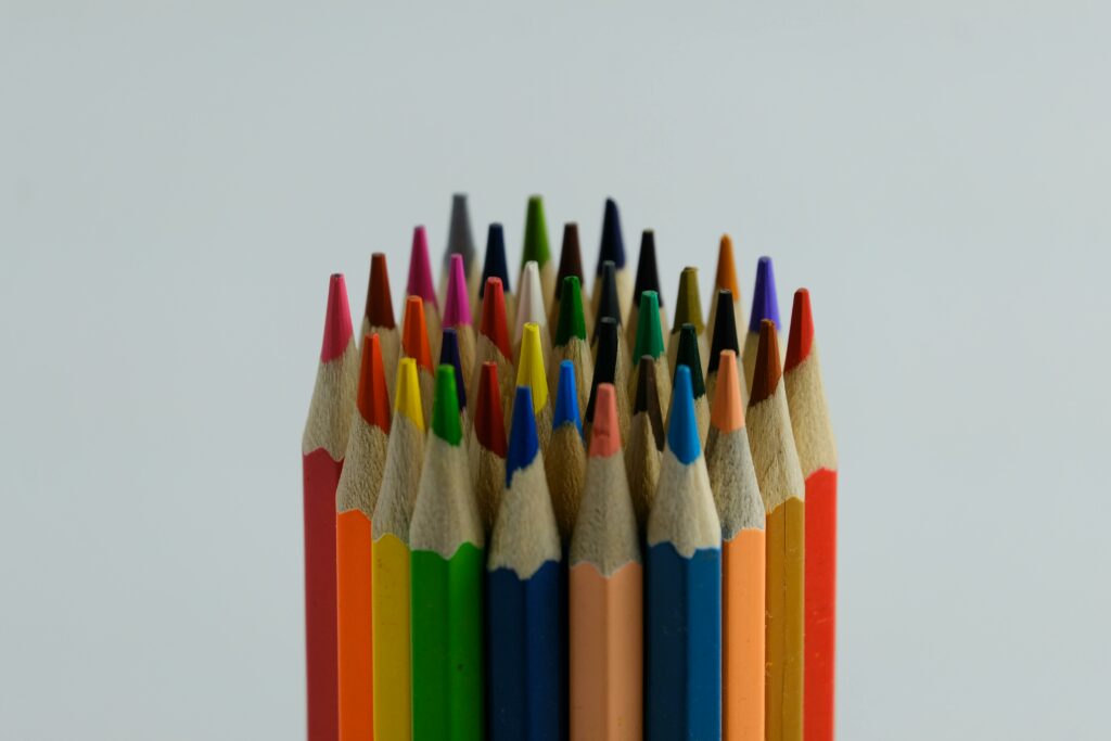 Close-up of assorted colored pencils arranged vertically, showcasing vivid hues on a white backdrop.
